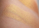AMATERASU swatched on the skin, lustrous bronze with golden shift.