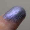 Adelaide eyeshadow shown close up and shimmering on a fingertip. Image of swatches on skin of Adelaide eyeshadow. Adelaide is a rich violet-blue with multi-tonal overlays of rose and violet.