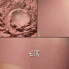 Collage showing Eir matte eyeshadow loose and swatched on the skin. Soft peachy pink buff. Matte finish.