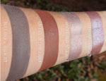 Skin swatches of contour powders and highlgters on medium tone caucasian skin. Rich terracotta brown/mahogany.
