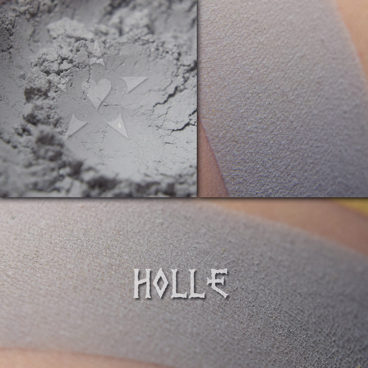 Holle matte finish eyeshadow shown loose and swatched on the skin. Soft blue-grey