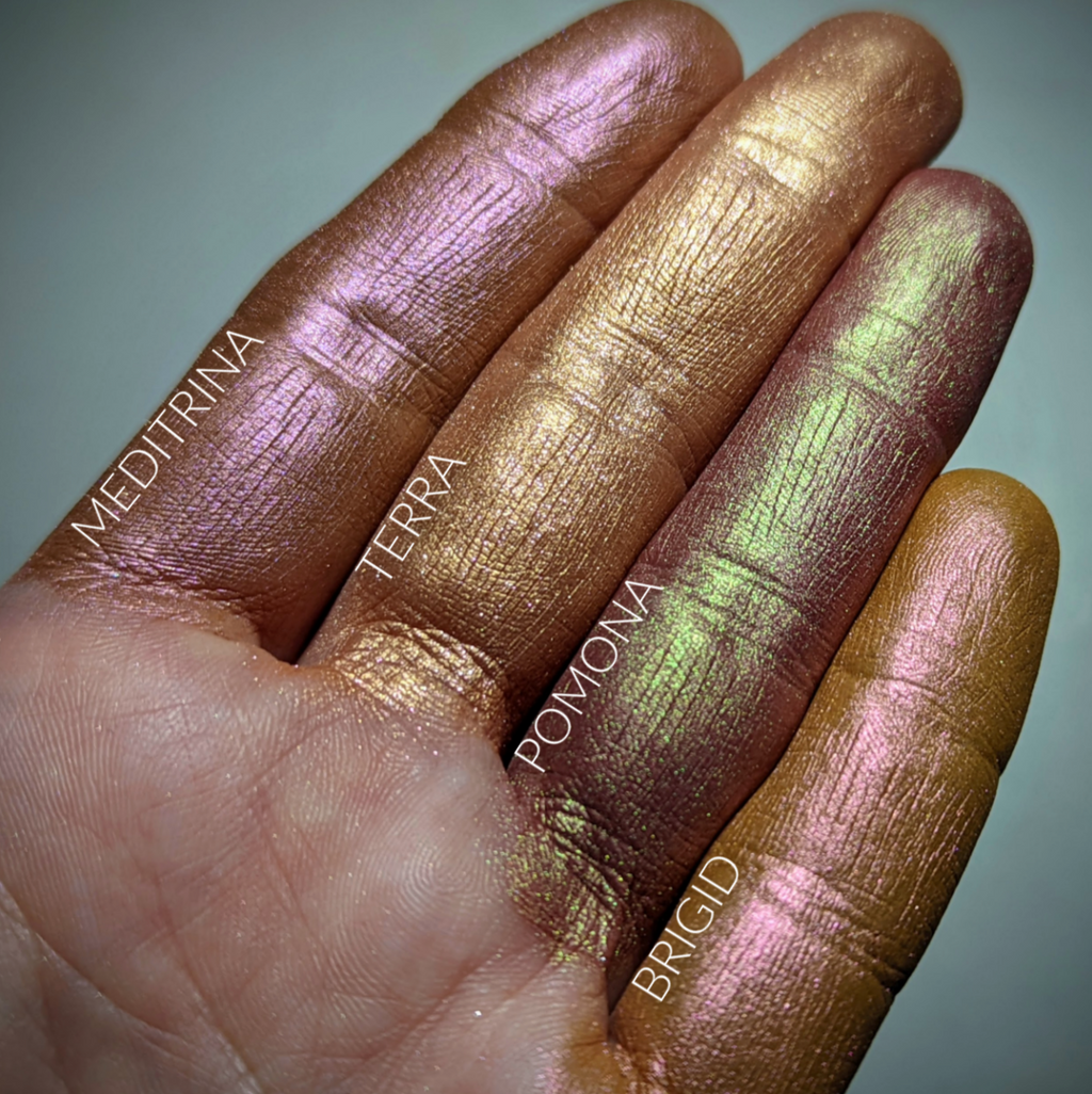 Meditrina loose and swatched on the skin. Meditrina is a warm-toned muted terracotta with a cooler violet iridescence