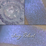 Tiny Bluet eyeshadow loose and swatched on the skin.  A pale blue-violet base with a strong violet shift.