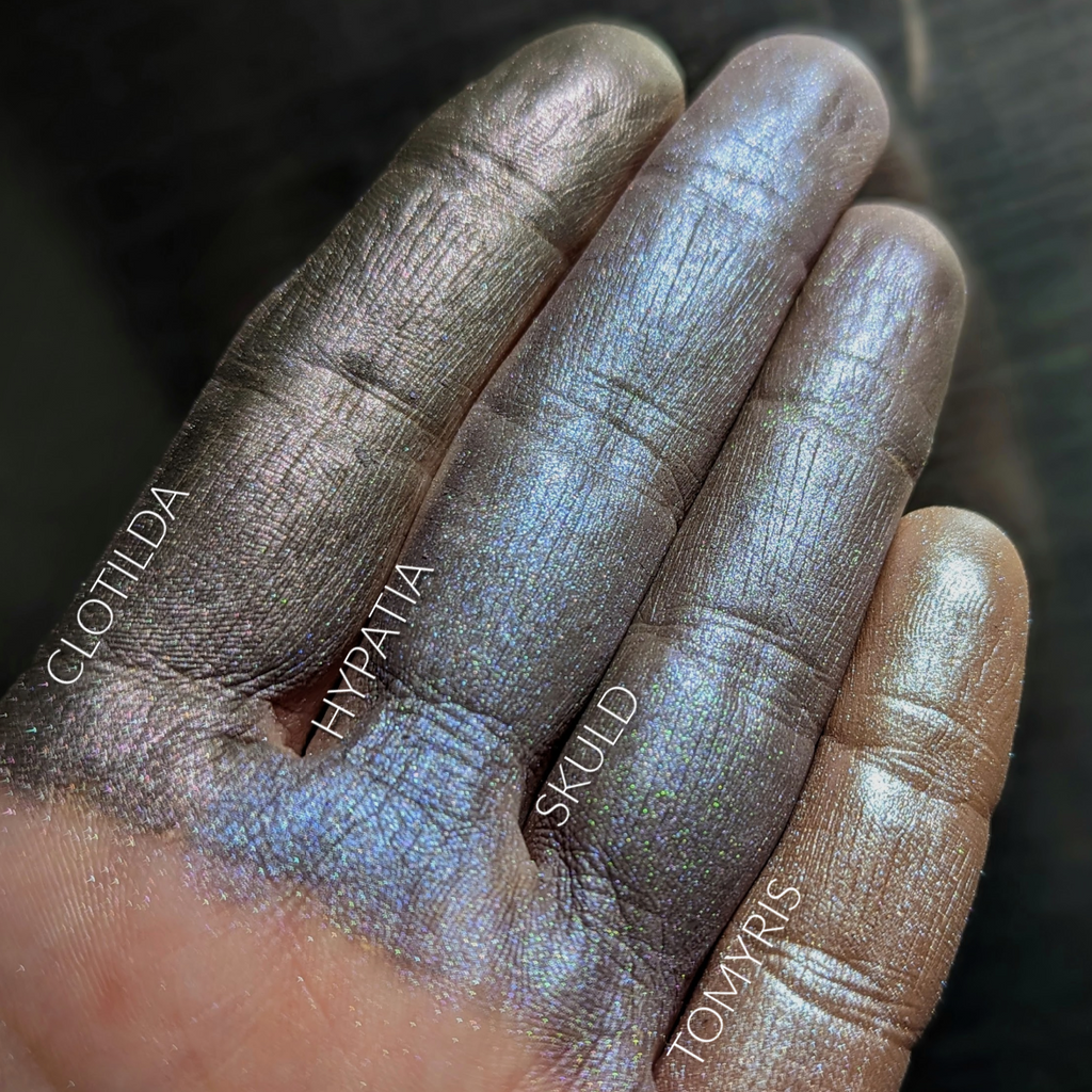 HYPATIA eyeshadow loose and swatched on the skin.  a very complex shade, with several layers of multichromal effect, to depict Hypatia's many studies. At it's core, it is a neutral grey- but it changes tone in different types of light!