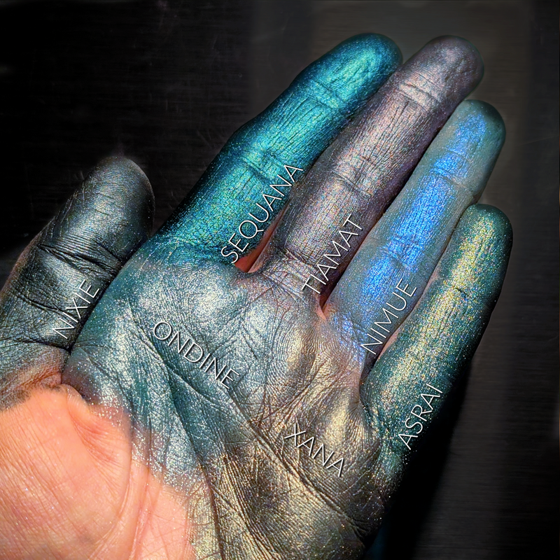 Hand with metallic blue and silver coloration, featuring names on the fingers against a dark background.