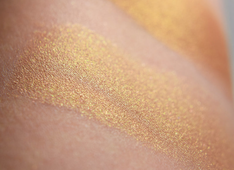 AMATERASU swatched on the skin, lustrous bronze with golden shift.