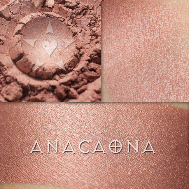Anacaona rouge is a buffed rosy copper. shown here loose and swatched on the skin moderately.