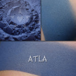 Atla matte eyeshadow in a collage. Shown loose and swatched on the skin. Deep but vibrant true blue, matte finish.