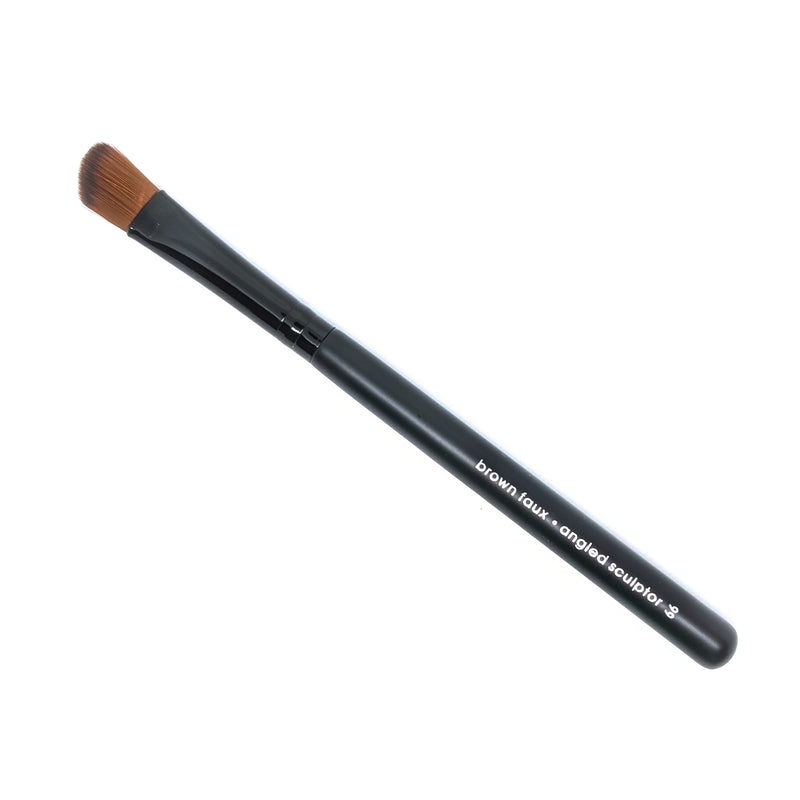 Brown faux angle sculptor brush with a matte black handle with silver writing depicting brush type, shiny black ferrule and brown brush tip hair. A angled, sculpted brush tip.