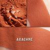 Arachne matte finish eyeshadow, A vivid terracotta orange. Shown loose and swatched heavily on the skin.