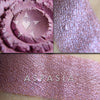 Collage of Aspasia eyeshadow shown loose and swatched on the skin. an exquisite orchid purple, with hints of copper, teal and indigo iridescence.