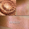 BRIGID - highlighter  loose and swatched on the skin. Brigid is a soft tangerine with a very strong pinkish red metallic glow.