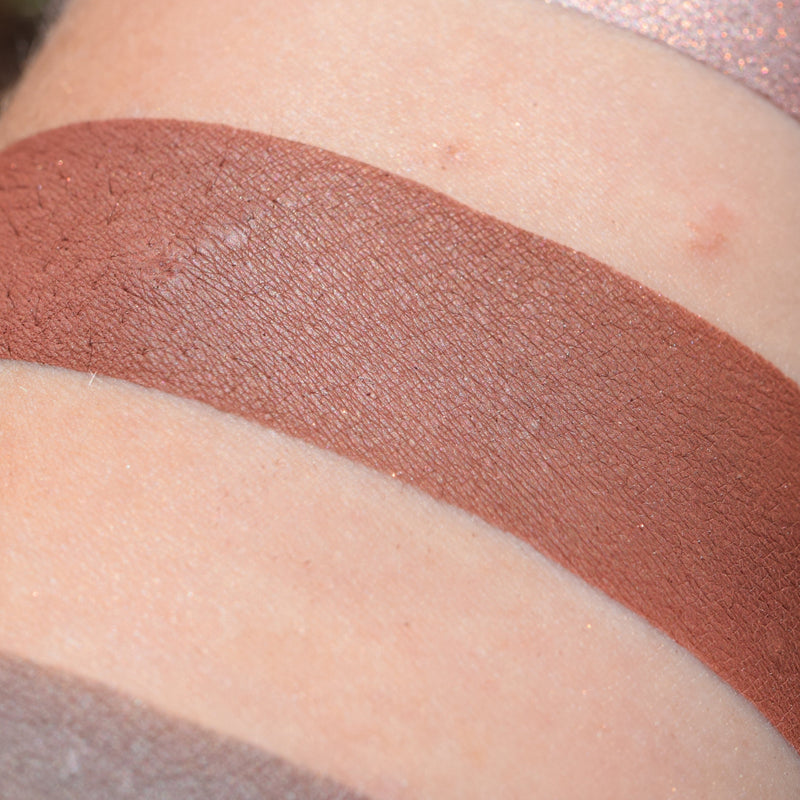 BACCHIC REVELRY- Multipurpose Contour/Eyeshadow swatched on medium tone caucasian skin. Rich terracotta brown/mahogany.