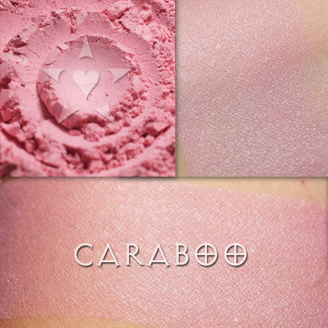 Caraboo rouge shown loose and swatched on the skin. A  a blushing rose pink with soft shimmer,