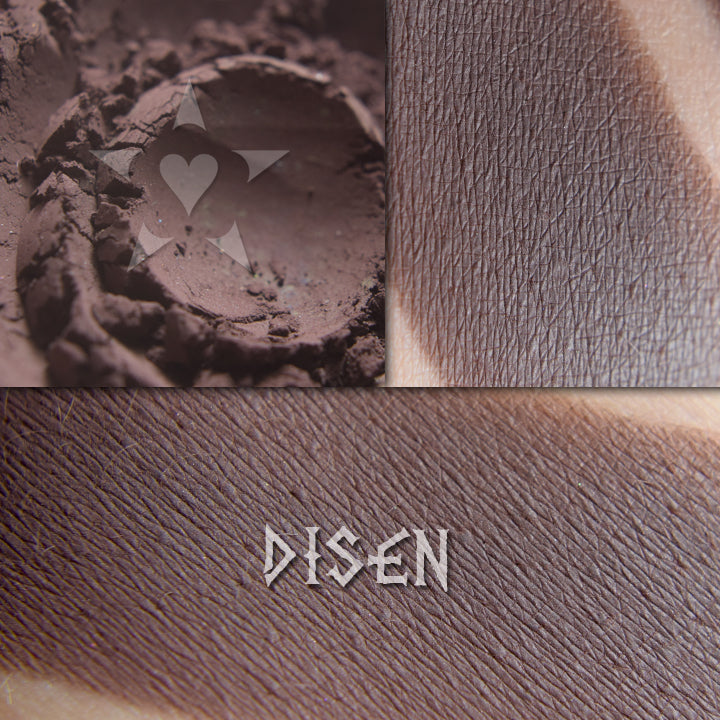 Disen eyeshadow in a collage shown loose and swatched on the skin. Dark cool mahogany. Matte finish.