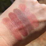 Lip cremes swatched on the back of the hand. Spirits Wept is second from left, reddish brown.