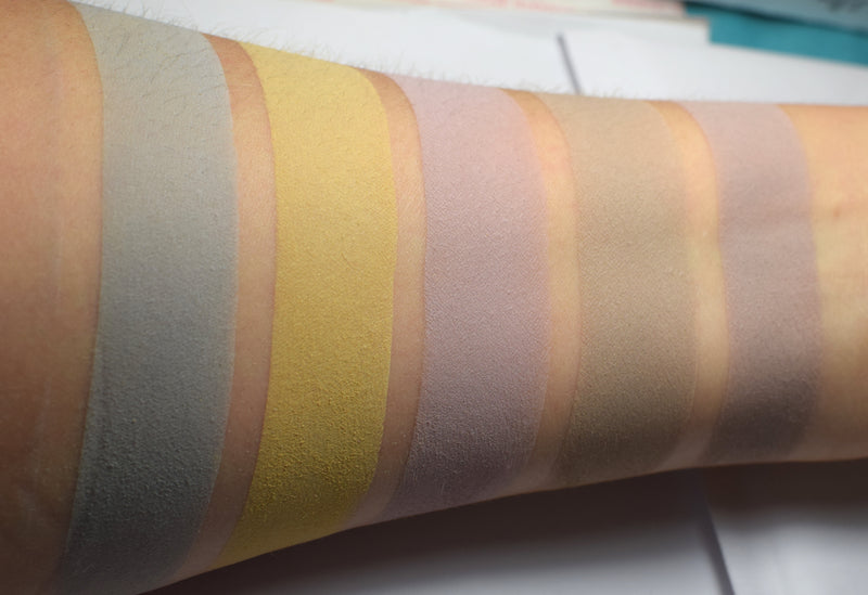 Skin swatches of matte eyeshadow on inner arm of medium tone caucasian skin. Kara is third from the left, a pale muted lilac.