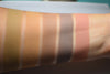 Skin swatches on inner arm of medium tone caucasian skin. Natural earthy brown warm tones. Hulda is second from right.  Cool slate/taupe