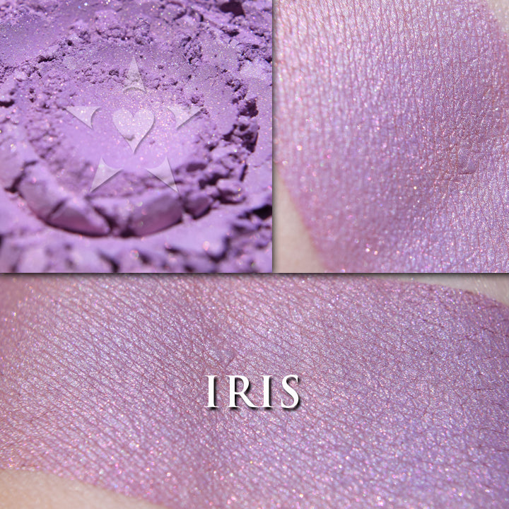 IRIS- Rouge loose and swatched on the skin. a wearable purple toned rouge, toned down and not overly vibrant, although it is buildable. It also has a warm peachy pink interference glow within it,