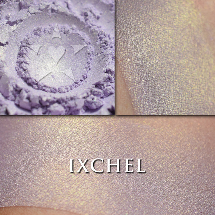 IXCHEL highlighter loose and swatched on the skin. Ixchel highlighter is a pale lavender with gold shift/glow.