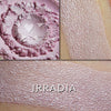 IRRADIA - Multipurpose Illuminator loose and swatched on the skin.  IRRADIA: A sheer glow of sweet pink with a delicate gold highlight.