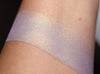 Ixchel swatched on medium tone caucasian skin. Ixchel highlighter is a pale lavender with gold shift/glow.