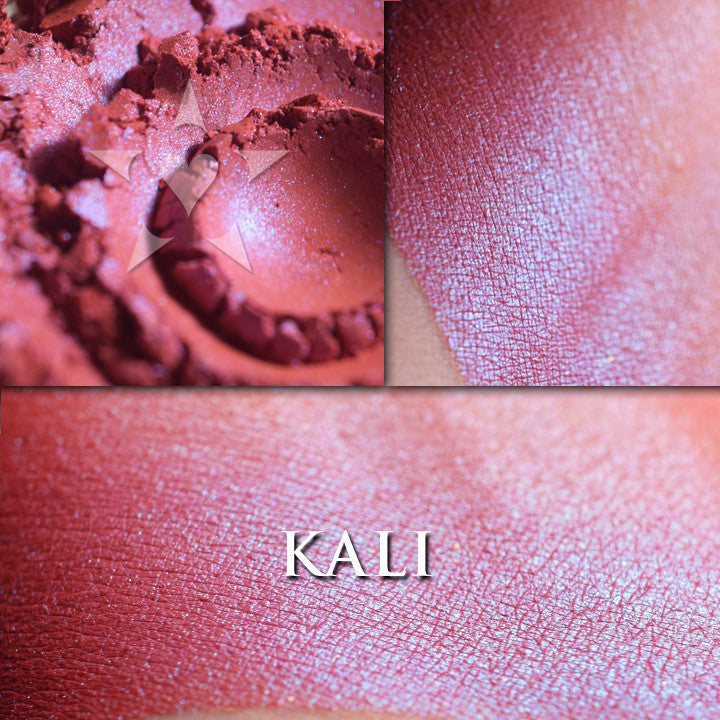 KALI rouge loose and swatched on the skin. Kali is a is a wearable red rouge with a strong blue inner glow.