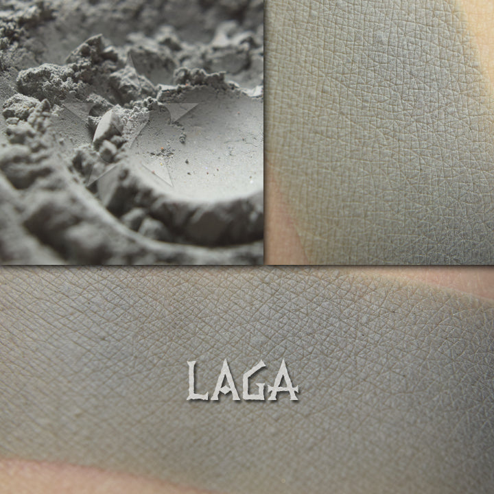 Laga matte eyeshadow shown loose and swatched on the skin. Heathered midtone gray/green