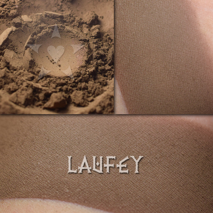 Laufey matte eyeshadow shown loose and swatched on the skin.  A deep golden brown with olive tones