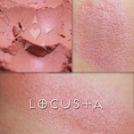 LOCUSTA eyeshadow shown loose and swatched on the skin. Locusta is a soft coral, with a delicate cool pink glow.
