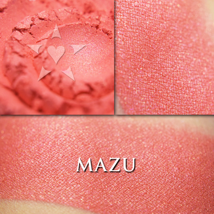 Mazu rouge loose and swatched on the skin.. Vivid coral with a slight shimmer,