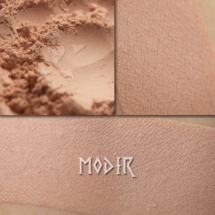 Modir matte eyeshadow shown loose and swatched on the skin. Pale muted peach