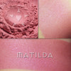 Matilda rouge loose and swatched on the skin. MATILDA is a cool, soft red with pink tones.