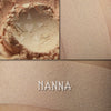 Nanna matte eyeshadow shown loose and swatched on the skin. Pale cream with peach tones.