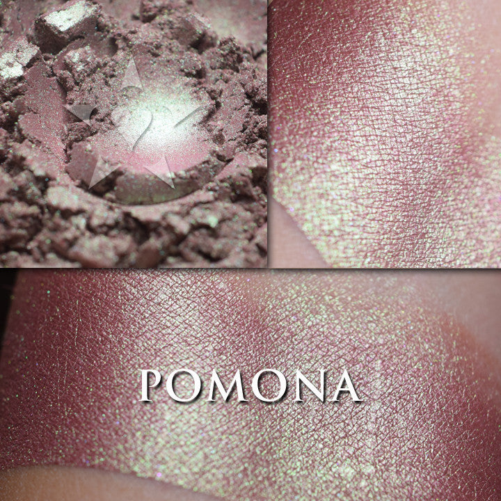 Pomona loose and swatched on the skin. POMONA, a mid-toned russet highlighter with a strong green shift,