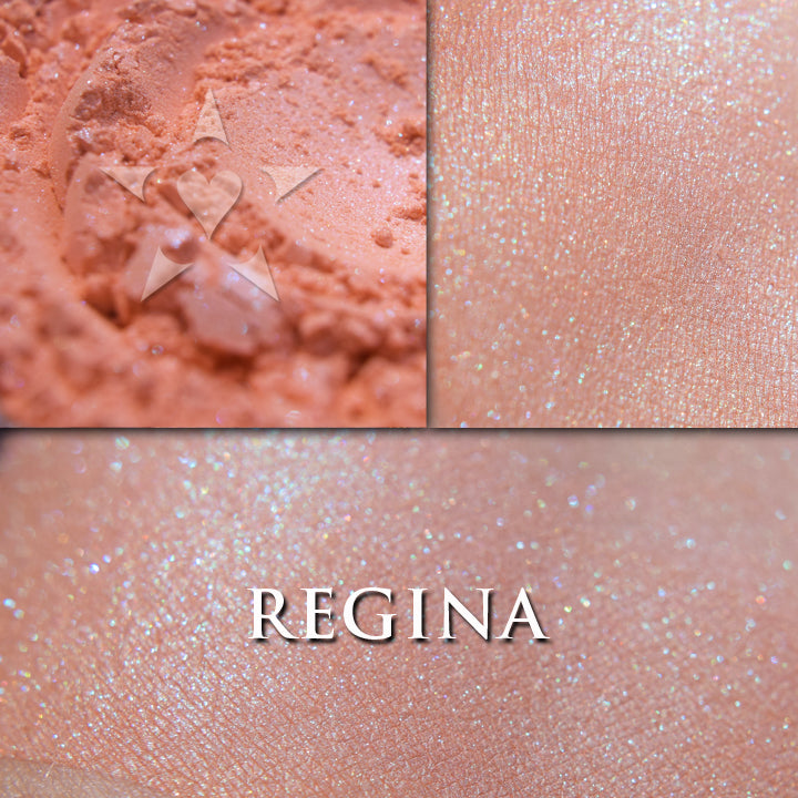Regina rouge loose and swatched on the skin.  Regina is a gorgeous sheer orange blush with coral tones and turquoise highlights.