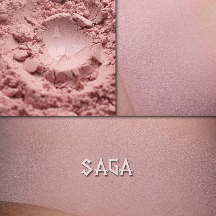 Saga matte eyeshadow shown loose and swatched on the skin. Soft petal pink
