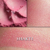Shakti rouge loose and swatched on the skin. Shakti is a bright but wearable coral-pink with a strong green shift.
