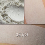 Skadi pure white matte eyeshadow shown loose and swatched on the skin.