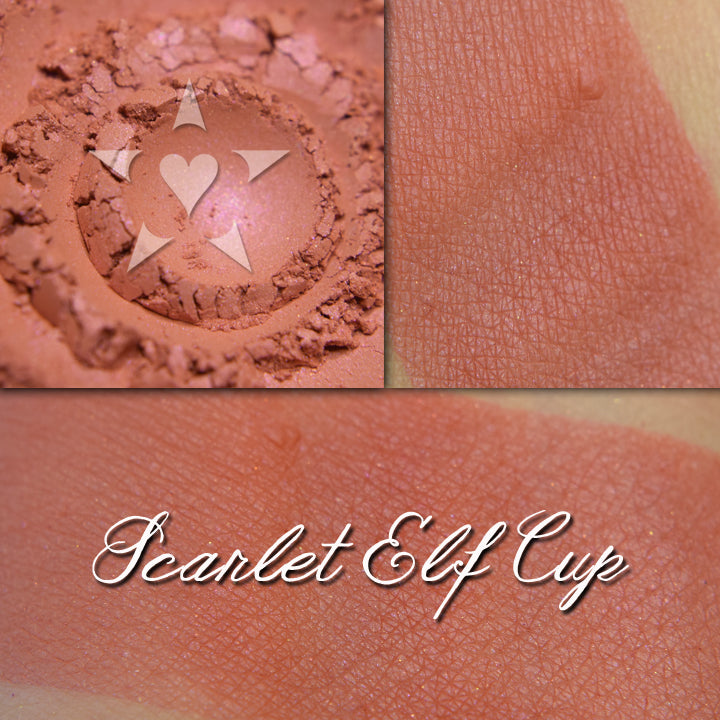 Scarlet Elf cup blush loose and swatched on the skin. Warm soft red with subtle pink/red iridescence.