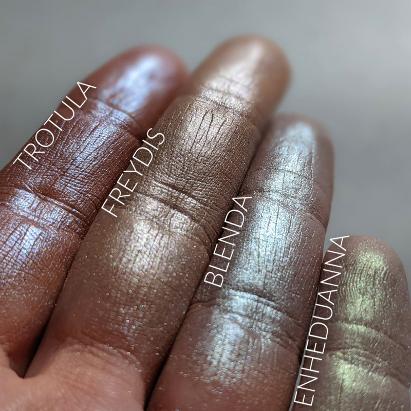 Neutral frost eyeshadows with iridescent highlights shown swatched on the fingertips. Blenda is second from right.