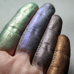Finger swatches of several Aromaleigh eyeshadows. Adelaide is shown on the second finger, Image of swatches on skin of Adelaide eyeshadow. Adelaide is a rich violet-blue with multi-tonal overlays of rose and violet.