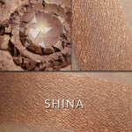 Shina illuminator loose and swatched on the skin. SHINA: Sheer glimmer of bronze and beige tones with a subtle peachy highlight.