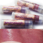 Transparent lip balm tubes, and spirits wept swatched on the skin. Reddish brown.
