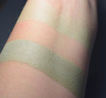 Synchlora swatched on medium tone caucasian skin over primer and bare skin. . A pale heathery green. 