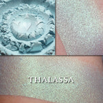 Thalassa highlighter loose and swatched on the skin. This glowy mermaid-like highlighter is a pale teal with strong green to gold iridescence