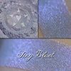 Tiny Bluet eyeshadow loose and swatched on the skin.  A pale blue-violet base with a strong violet shift.