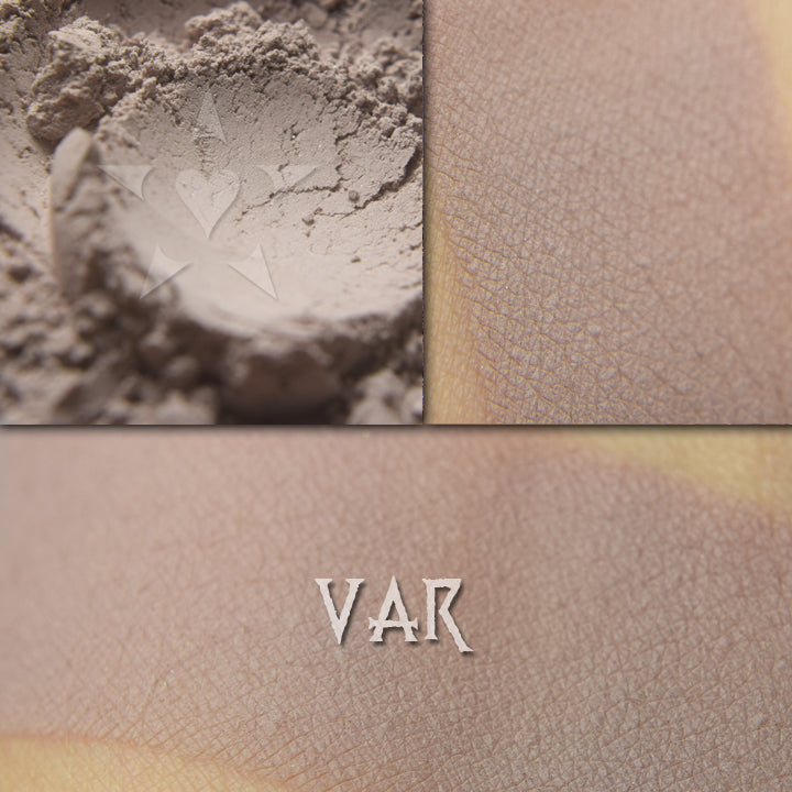 Var matte eyeshadow shown loose and swatched on the skin. Muted mauve-taupe.