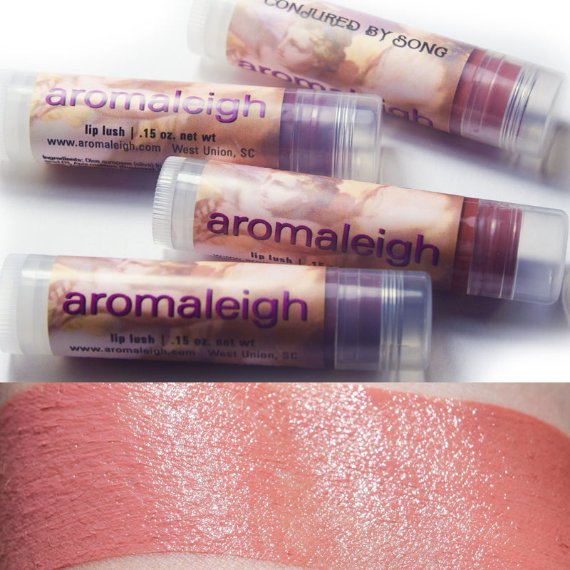 Transparent lip balm tubes with What Love Does Seek swatched on the skin.  Petal pink with peach tones