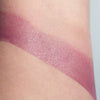 Image shows this lip color lightly swatched on the inner arm. A soft warm purple.